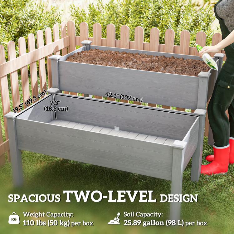 Gray two-tier raised garden bed planter with open top compartments and soil