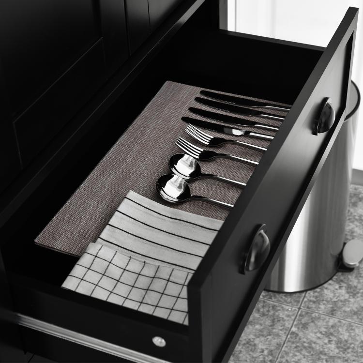 Black cabinet drawer interior with utensil dividers and folded linens