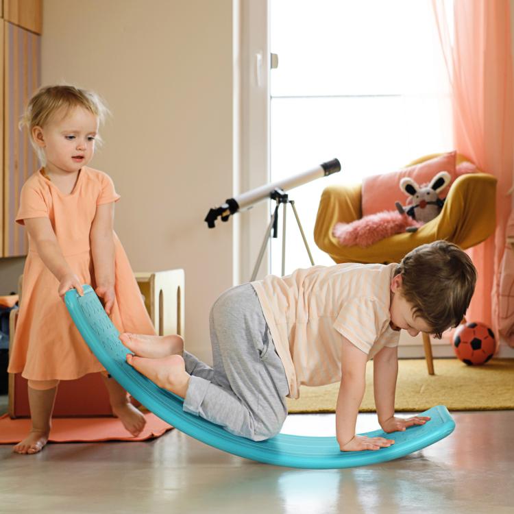 Turquoise-blue balance board for toddlers, shown rocking on the floor