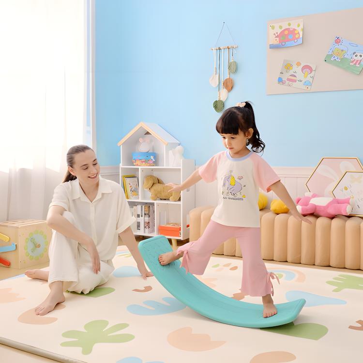 Turquoise-blue balance board with children using it on a colorful play mat