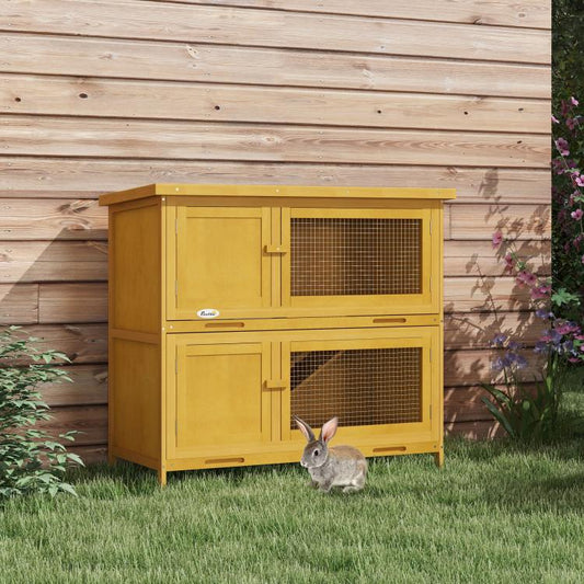 Open-front wooden rabbit hutch with wire mesh panels, yellow, outdoors on grass
