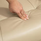 Cream recliner seat upholstery close-up with hand smoothing the surface