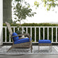Wicker lounge chair and ottoman with blue cushions on outdoor deck