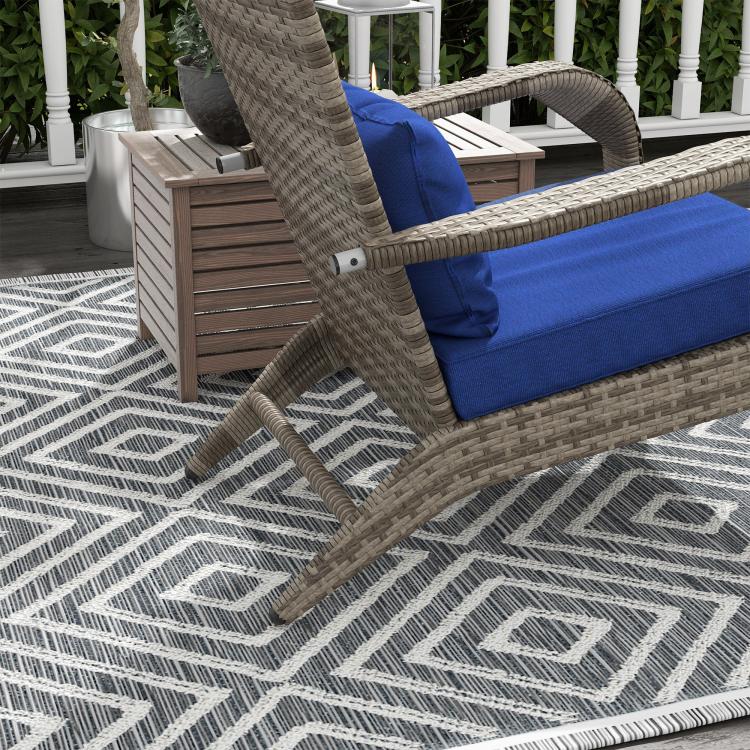Wicker lounge chair with blue seat cushion and matching ottoman, side view
