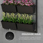 Black planter pots with drainage hole detail on a 3-tier wall system