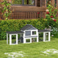 Outdoor two-story rabbit hutch in dark gray and white with enclosed side run
