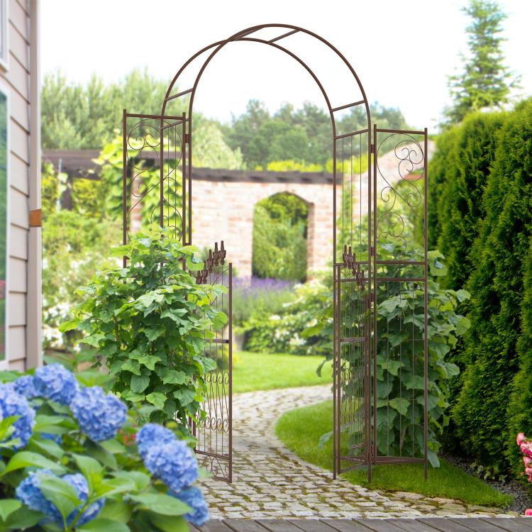 Brown metal garden arch arbor gate along a garden path with tall hydrangeas