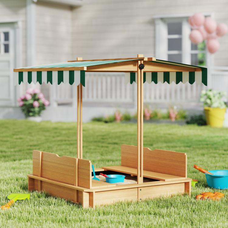 Kids wooden sandbox with striped canopy and bench seats on grass, open side view