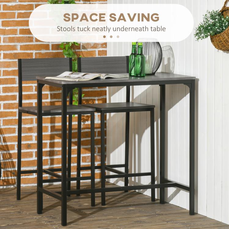 Gray counter-height bar table with two stools tucked beneath for space saving.