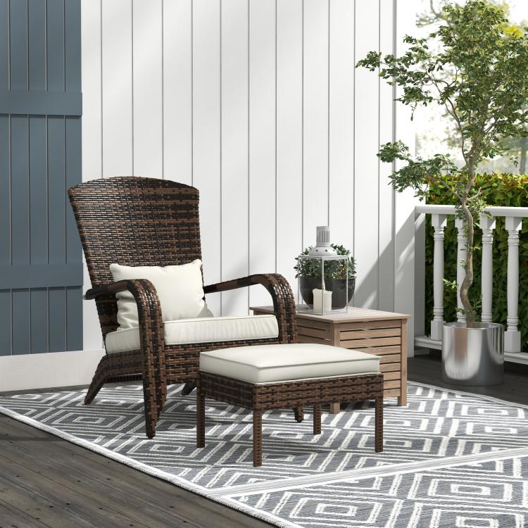 Outdoor brown wicker armchair with high back, white cushions, and ottoman