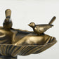 Close-up of bronze shell basin with bird statue accents and ridged bowl details