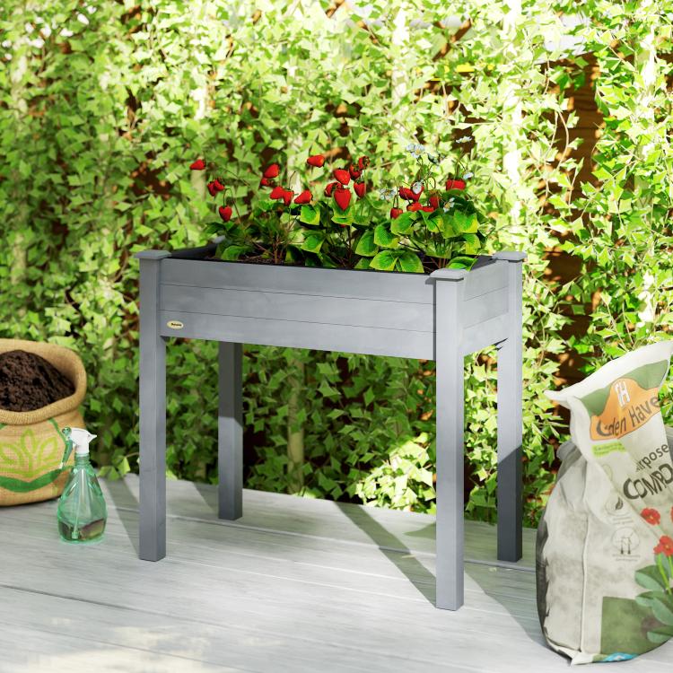 Raised dark gray planter box on four legs, filled with leafy plants
