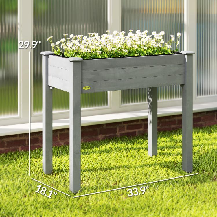Dark gray raised wooden planter box with planted white flowers and four legs