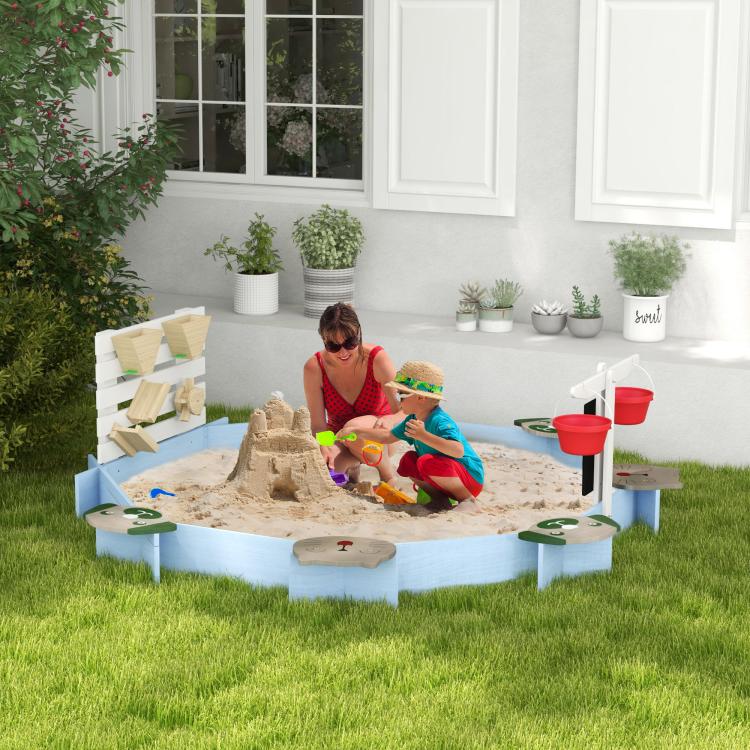 Blue wooden sandbox with children playing in sand, white side panels, and red buckets