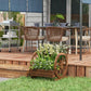 Wooden wagon planter box with stacked tiers, holding white flowers in a yard