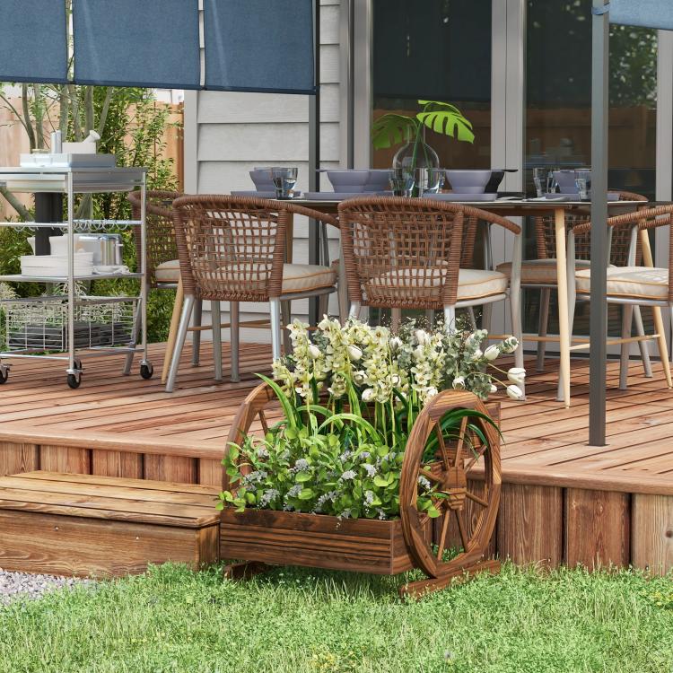 Wooden wagon planter box with stacked tiers, holding white flowers in a yard