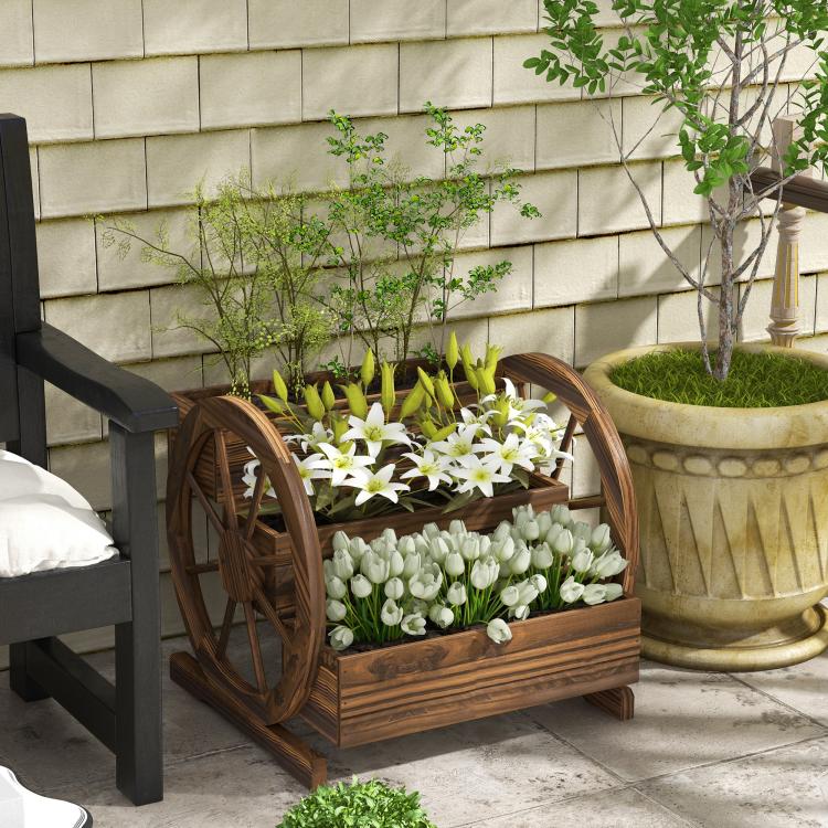 Wooden wagon planter box with wheel accents, holding white flowers and green plants