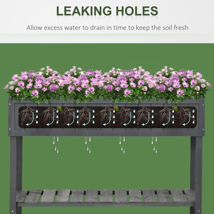 Dark gray raised planter bed with drainage holes along the bottom of the planter