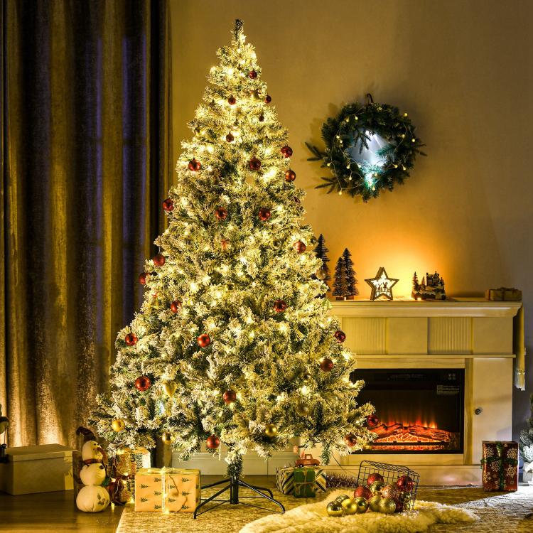Artificial Christmas tree with frosted branches and warm white LED lights, fully lit