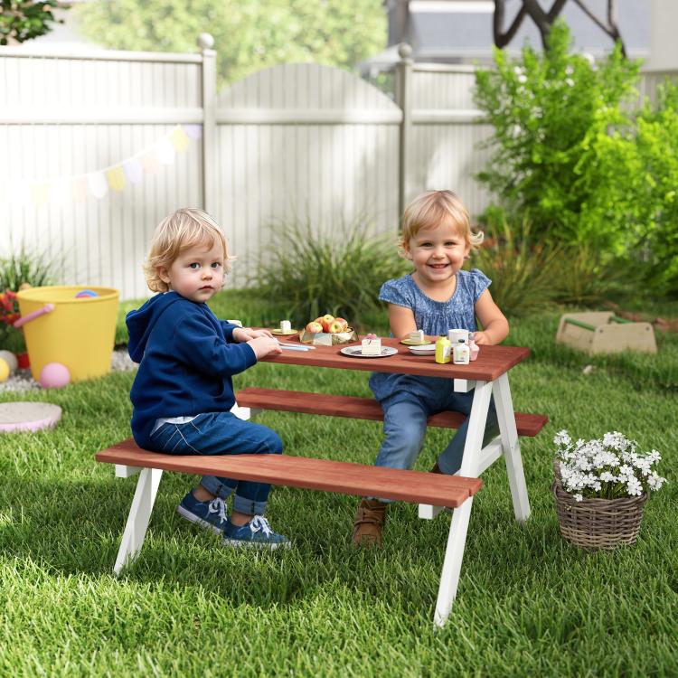 Kids wooden picnic table set with bench seating, brown tabletop and white legs in a yard
