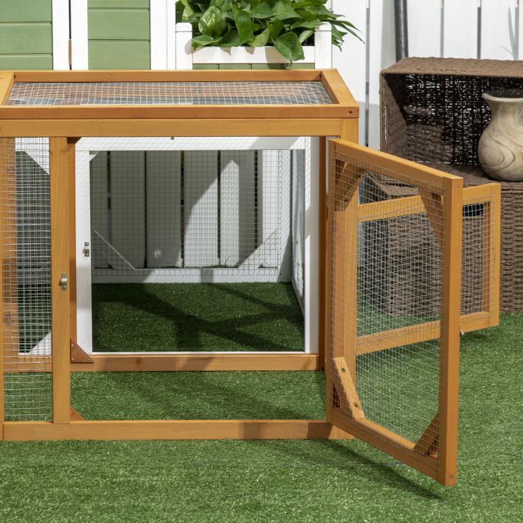 Wooden chicken coop expansion with wire mesh sides and open access door