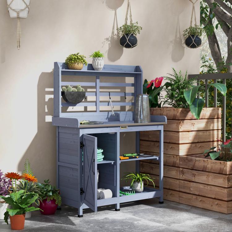 Gray potting bench with shelves, hanging hooks, and open tabletop storage