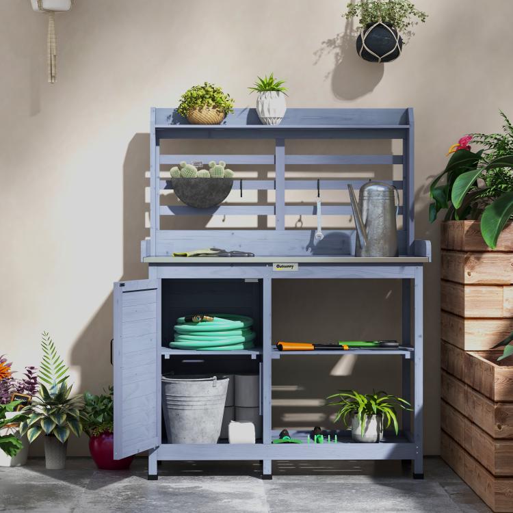 Gray potting bench with open cabinet shelves and gardening tool tabletop
