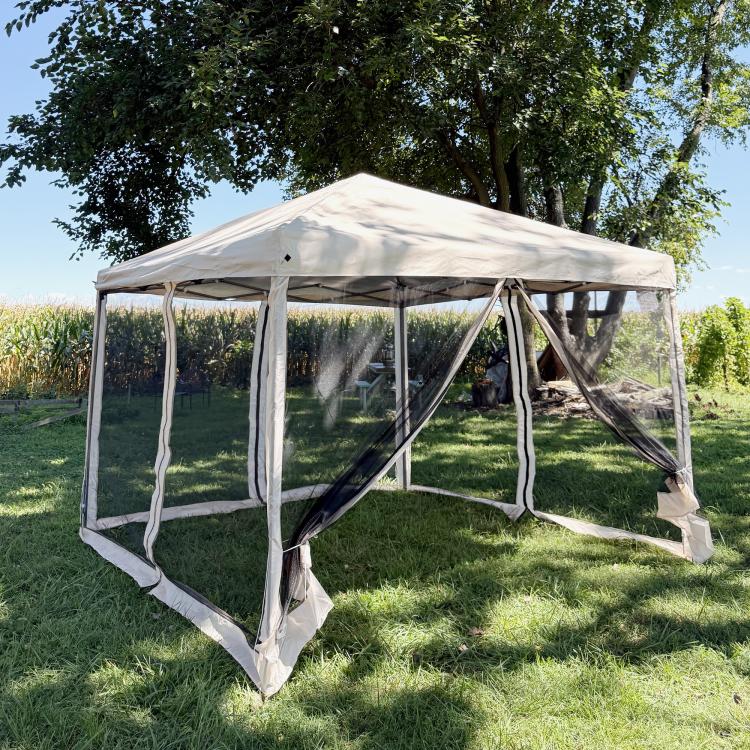 Beige pop-up canopy tent with enclosed dark netting sides and front zip door