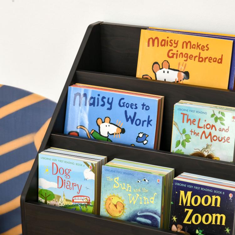 Kids book rack close-up with front books in top display and open shelf cubbies.