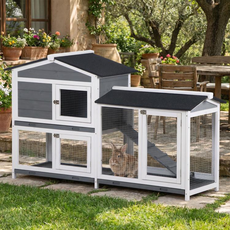 Outdoor rabbit hutch with two levels, black roofs, wire mesh windows, and ramp