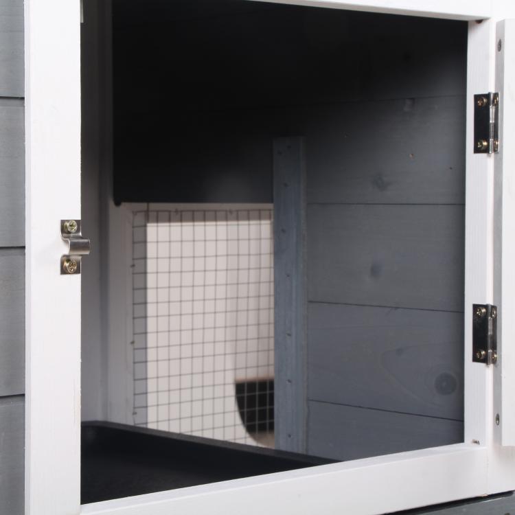 Open side door of 2-tier rabbit hutch showing dark interior and white wire divider