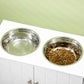 Close-up of two stainless steel dog bowls on a white raised feeding stand