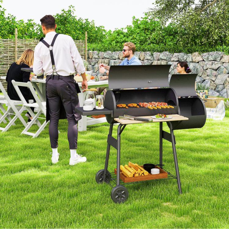 Charcoal BBQ grill and smoker combo on wheels, open hood and side prep tray