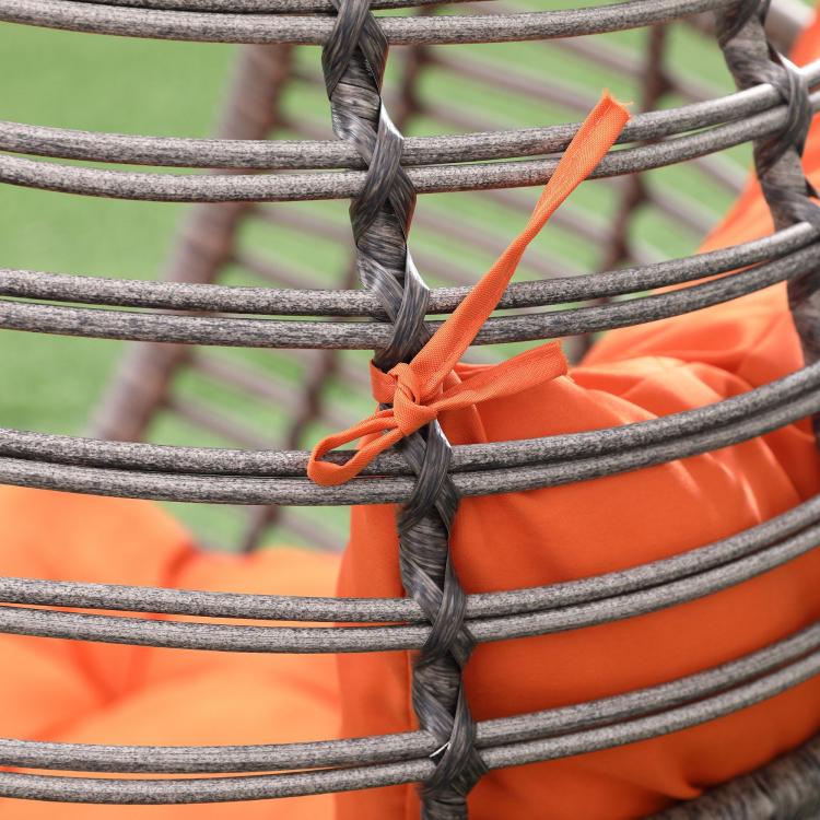 Egg chair cushion attachment detail with orange tie straps on dark wicker rungs