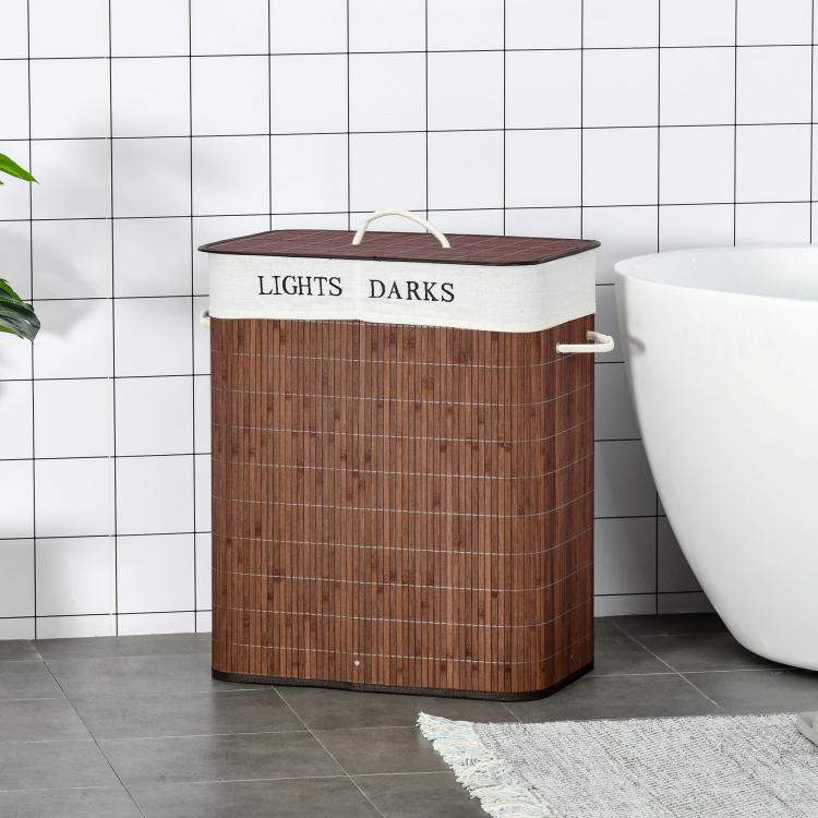 Brown bamboo laundry basket with lid and side handle, standing in bathroom setting
