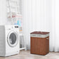 Brown bamboo laundry hamper with lid and string handle, next to washing machine