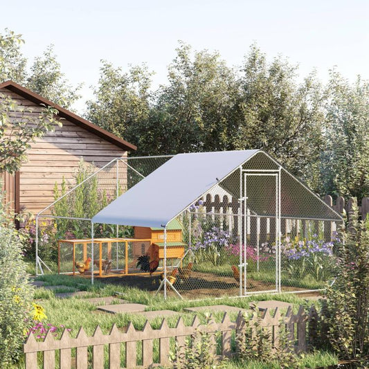 Outdoor chicken coop with gray awning-style roof and wire mesh enclosure in garden yard