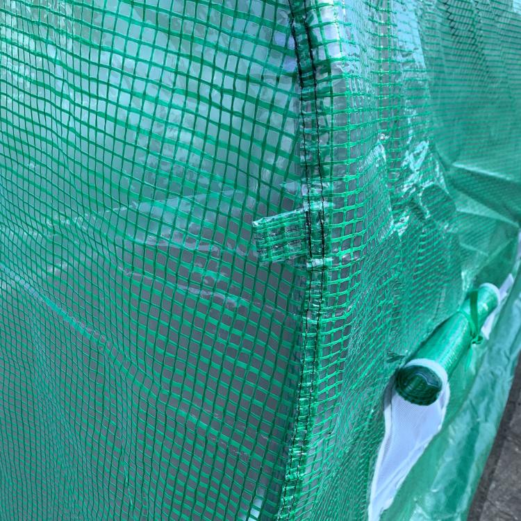 Green PE cover greenhouse close-up of mesh seam and fastening grommet
