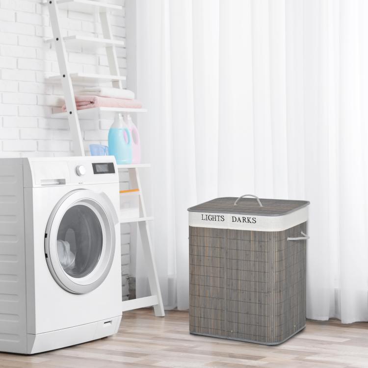 Gray bamboo laundry hamper with lid and side handles, next to a washing machine