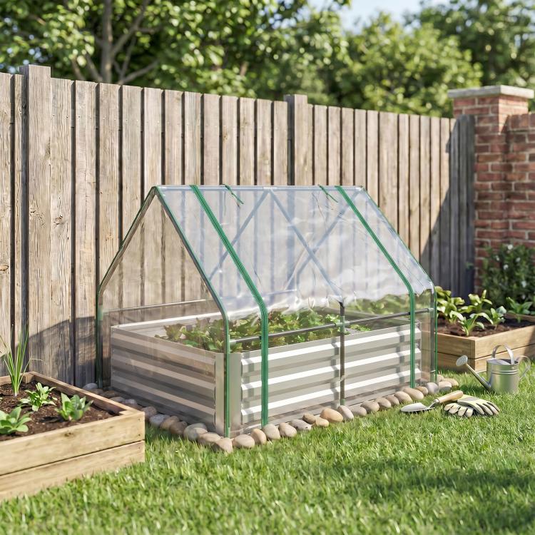 Clear-covered raised planter box with green frame in a backyard garden bed area