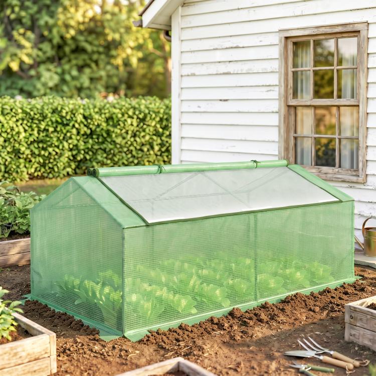 Portable mini greenhouse with green mesh walls and zippered window panels, outdoor use