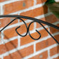 Black steel garden fence panel with curved vine border and arched scroll detail