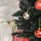 Black artificial pencil Christmas tree with dense tips and gold ornament