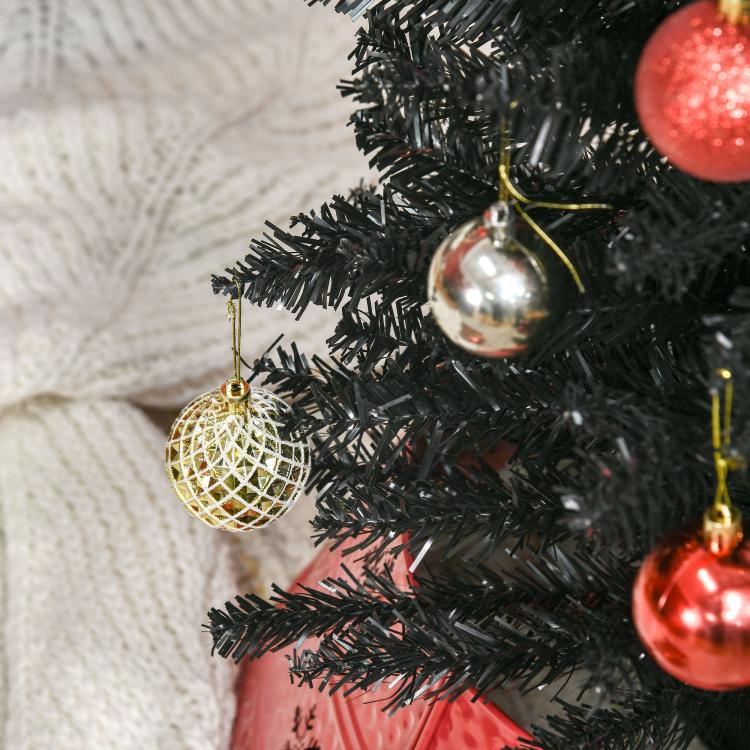 Black artificial pencil Christmas tree with dense tips and gold ornament