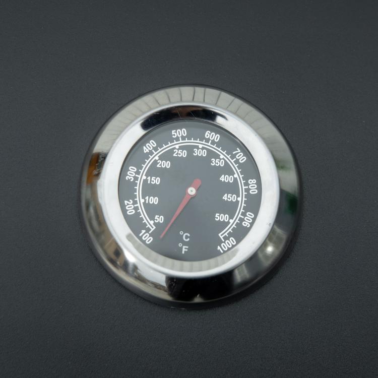Black grill lid thermometer gauge with temperature markings close-up