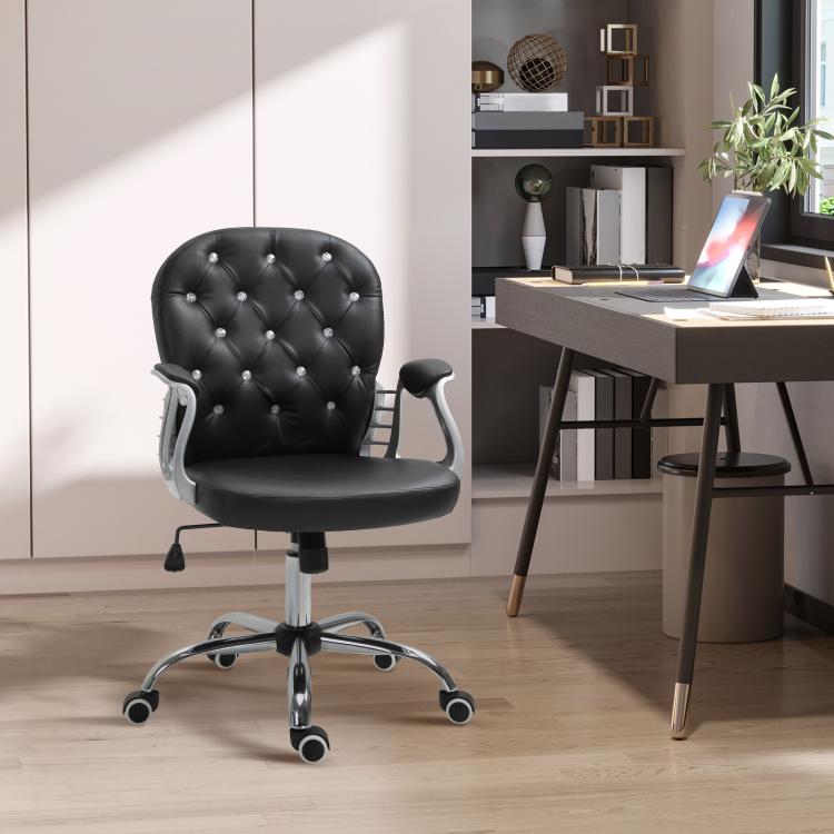 Black tufted swivel desk chair with padded armrests and chrome base, in home office