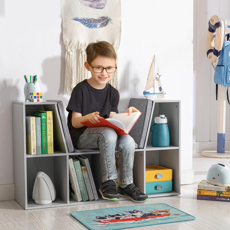 Kids reading nook bookcase with grey cushion, open cubbies, and stacked books and toys