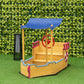 Boat-style kids wooden sandbox with blue canopy and red wheel at play station