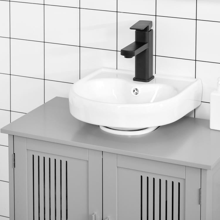 Grey under-sink bathroom cabinet with slatted door panels and mounted sink top.