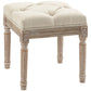 Beige upholstered ottoman footrest with tufted seat and carved wooden legs, corner accents